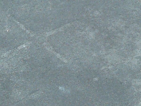 Asphalt texture, blue-grey in color, with blotchy light areas and small amounts of irregular cracking.